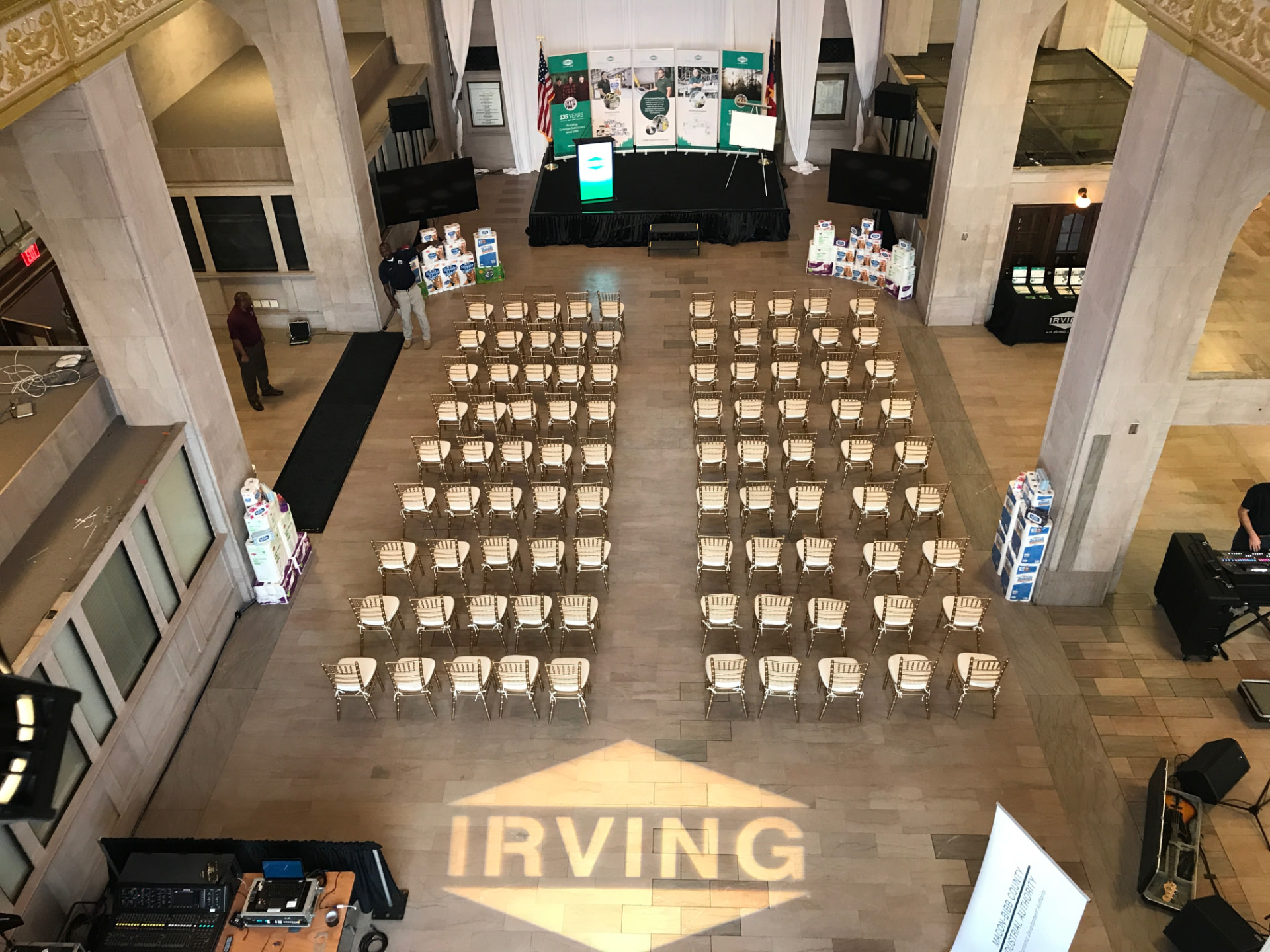 Historic hall set with theater seating, stage, monitors and a gold custom gobo projected on the floor